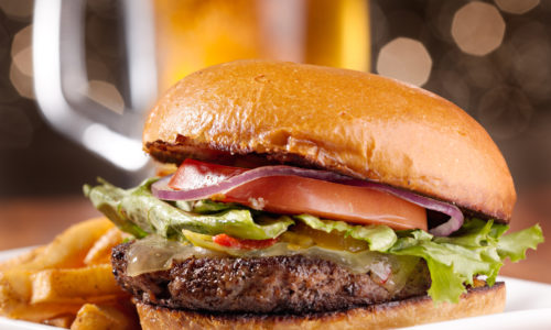 gourmet cheeseburger with mug of beer in background gourmet cheeseburger with mug of beer in background